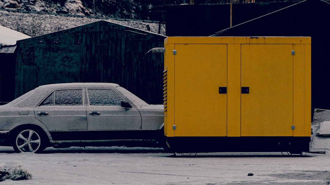 a-car-parked-next-to-a-yellow-trailer-8i6s8h6xlq8